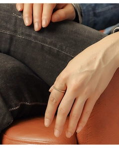 Close-up of a minimalist gold-plated twist rope ring worn as an elegant pinky finger ring
