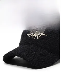 Close-up of black fleece texture and white HEART embroidery on warm winter baseball cap