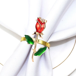 Detailed close-up of a red rose napkin ring with sparkling diamonds on a white fabric