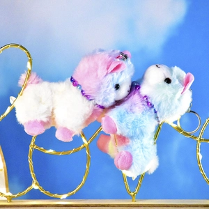 Close-up of cute rainbow kitten plush pendants displayed on a decorative gold wire frame