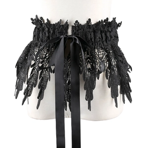 Detail showing intricate black lace texture and satin bow tie on elastic waist belt