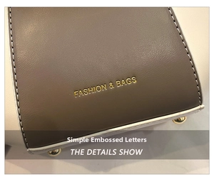 Detail of grey leather handbag base with gold lettering and protective metal feet
