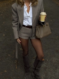 Detail of a brown plaid suit and shorts set featuring a notched lapel and white shirt