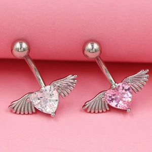 Piercings de nombril avec cœurs ailés en cristal rose et blanc sur fond rose pastel