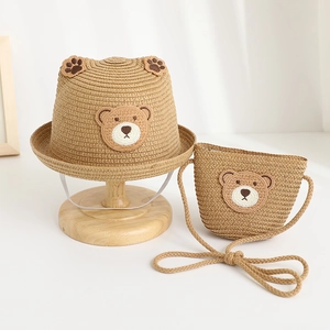 Detail of straw sun hat and matching bag with cute bear ears for kids' summer travel