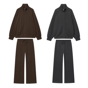 Flat lay of soft zip-up hoodies and straight-leg sweatpants in dark brown and charcoal grey