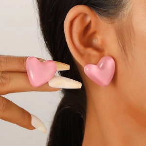 Chic pink heart-shaped stud earrings shown on ear for a trendy, minimalist feminine look