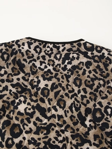 Detail of leopard print quilted jacket showing neckline texture and black binding trim