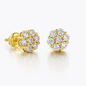 Close-up of gold flower stud earrings featuring sparkling pave diamonds on white background