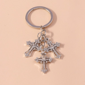 Close-up of sparkling silver cross keychain with rhinestones for handbags and accessories