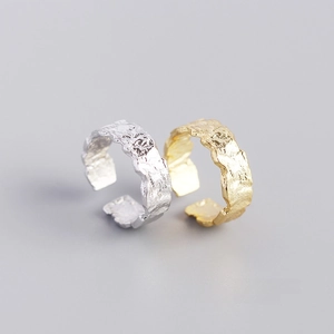 Detailed view of silver and gold 7mm adjustable rings with irregular foil texture