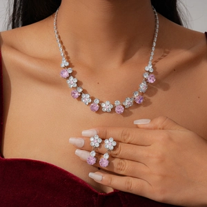 Detail view of pink floral zircon jewelry set with necklace and drop earrings on model