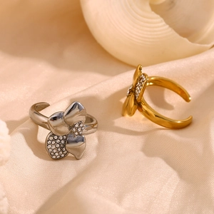 Detailed view of asymmetric floral rings with crystals in gold and silver finishes