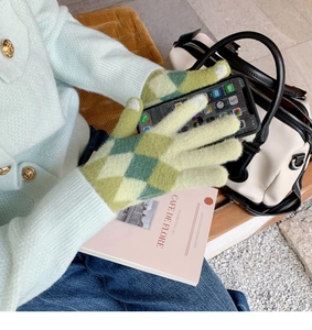 Close-up of green diamond pattern knit gloves with touchscreen function for smartphones