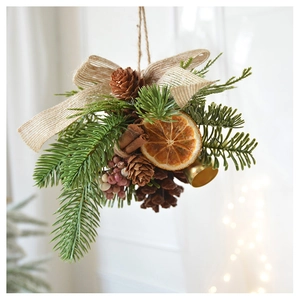 Close-up of pine cone hanging ornament with orange slices, cinnamon and burlap bow