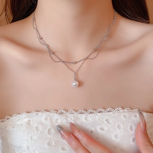 Gros plan sur l'élégant collier double couche en argent avec perle sur un mannequin