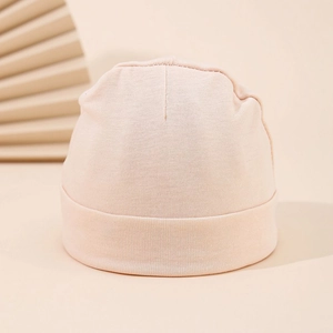 Close-up of soft cotton texture on a warm pink newborn winter beanie for babies
