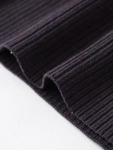 Detailed close-up of dark charcoal ribbed knit fabric texture on a casual sweater