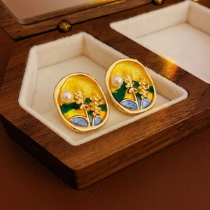 Vintage enamel earrings with floral design, gold frame and pearl detail on display