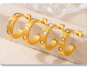 Detail of 18K gold plated C-shaped hoop earrings with three sparkling round zircons