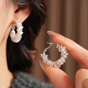 Elegant geometric silver hoop earrings with irregular diamond crust and icy crystal finish