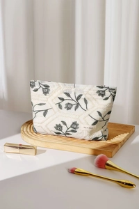 Detail shot of heavy canvas makeup bag with floral embroidery and gold zipper closure