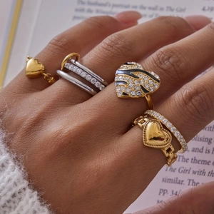 Detail of assorted heart rings with drip oil and rhinestones worn by a model