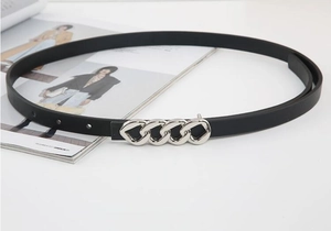 Detail of slim black leather belt with silver chain buckle on a stylish magazine background