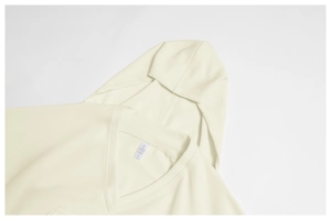 Close-up of neckline and tag showing the 62% cotton blend fabric of the beige hoodie