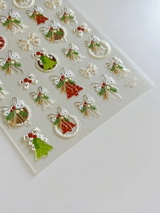 Detailed view of 3D embossed Christmas nail art stickers featuring wreaths and bells