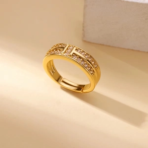Detailed macro view of an adjustable gold H-shaped ring with pavé-set zircons and stones