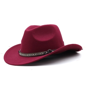 Detail of burgundy felt fedora featuring an ethnic woven band with leather and metal studs