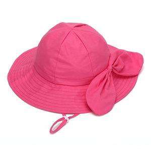 Detail of rose red sun hat featuring wide brim, decorative bow, and adjustable chin strap