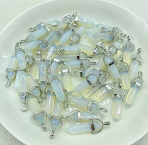 Macro view of opalite hexagonal crystal pendants with silver metal clasps on a white plate