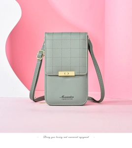 Detailed view of sage green textured phone bag with gold clasp and adjustable strap