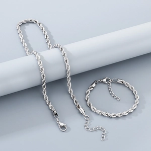 Détail d'un ensemble de collier et bracelet torsadés argentés avec fermoir mousqueton