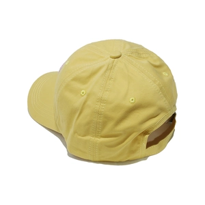 Detail view of the pale yellow baseball cap showing adjustable strap and cotton twill texture