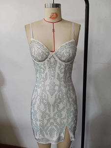 Detail of white bodycon dress with silver rhinestones and baroque patterns