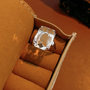 Close-up of a square zircon ring with 14k gold plating in a brown velvet jewelry box