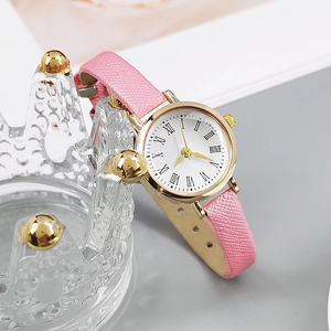 Close-up of pink leather strap and gold quartz watch on a crown jewelry holder