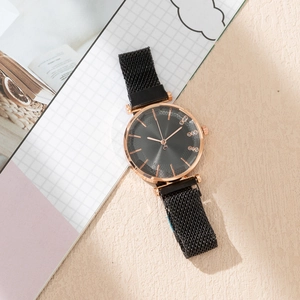 Détail d'une montre à quartz or rose avec cadran noir soleil et bracelet milanais
