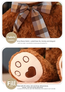 Detail of terry fleece teddy bear featuring checkered bow and heart embroidered foot