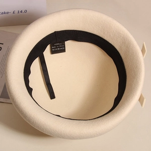 Detail view of the beige wool beret interior with adjustable drawstring and quality lining