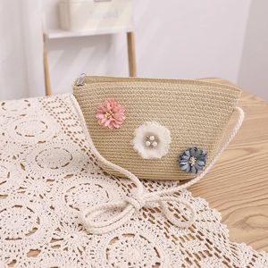 Détail du sac bandoulière en paille fait main avec fleurs et ornements en perles