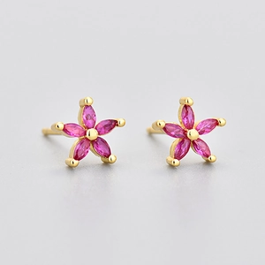 Detailed close-up of gold five-petal flower stud earrings with vibrant rose pink zircons