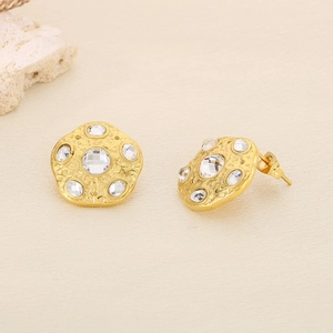 Detailed view of irregular hammered gold stud earrings with sparkling crystal rhinestones