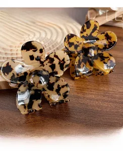 Macro detail of tortoiseshell flower hair claw clips in amber and ivory acetate finish