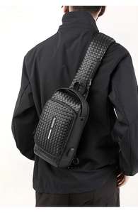 Detail of black woven leather chest bag for men with fashion label and USB port