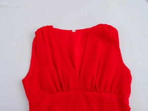Detail of red V-neck dress with ruched chest design and size S label on chiffon fabric