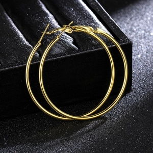 Close-up of high-polish gold hoop earrings on a black velvet jewelry display